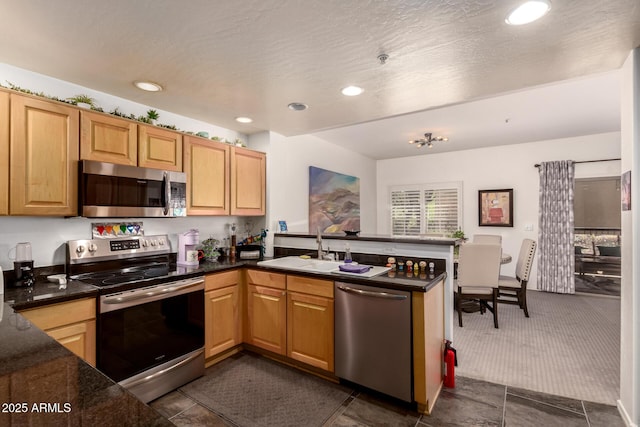 19700 N 76th St Unit 1040, Scottsdale, AZ 85255 - kitchen featuring stainless steel appliances, a peninsula, recessed lighting, dark carpet, and dark stone counters