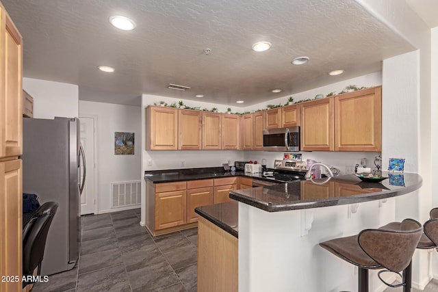 19700 N 76th St Unit 1040, Scottsdale, AZ 85255 - kitchen with appliances with stainless steel finishes, a peninsula, a breakfast bar, recessed lighting, and dark stone counters
