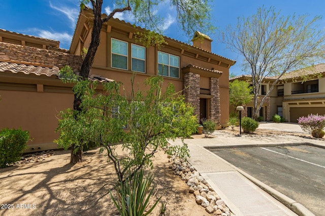 19700 N 76th St Unit 1040, Scottsdale, AZ 85255 - view of front of home with stucco siding, a chimney, uncovered parking, and a tile roof