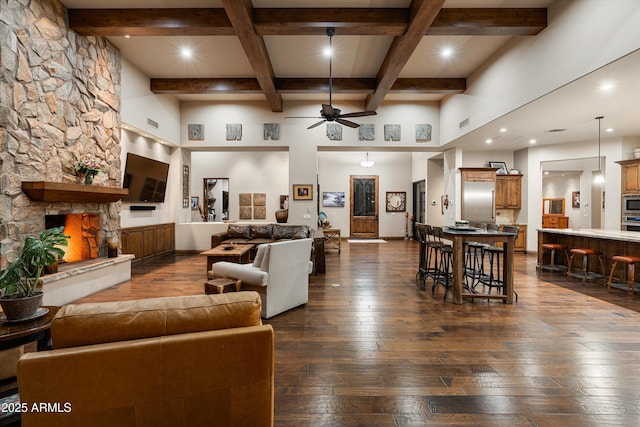 4610 E Meadowview Dr, Gilbert, AZ 85298 - living room with ceiling fan, dark wood finished floors, a stone fireplace, beamed ceiling, and a high ceiling