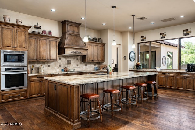 4610 E Meadowview Dr, Gilbert, AZ 85298 - kitchen with appliances with stainless steel finishes, custom exhaust hood, a large island, dark wood-style floors, and tasteful backsplash