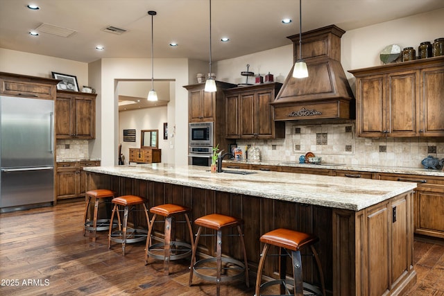 4610 E Meadowview Dr, Gilbert, AZ 85298 - kitchen with built in appliances, backsplash, dark wood finished floors, a sink, and a large island with sink