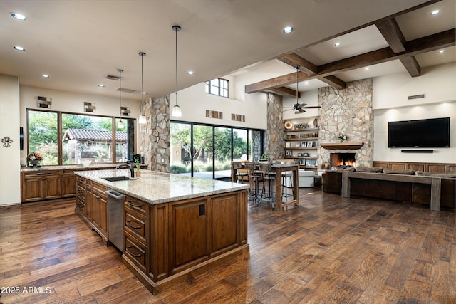 4610 E Meadowview Dr, Gilbert, AZ 85298 - kitchen featuring a ceiling fan, a fireplace, dark wood-type flooring, beamed ceiling, and light stone countertops