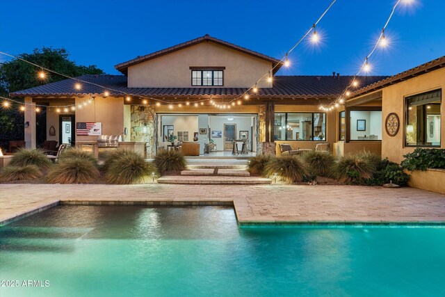 4610 E Meadowview Dr, Gilbert, AZ 85298 - back of property featuring a patio area, stucco siding, an outdoor pool, and stone siding