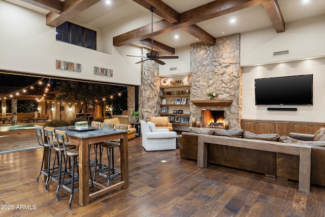 4610 E Meadowview Dr, Gilbert, AZ 85298 - living area featuring ceiling fan, beamed ceiling, a fireplace, wood finished floors, and a high ceiling