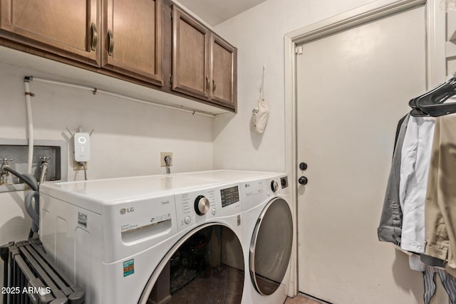 clothes washing area featuring washing machine and dryer and cabinets