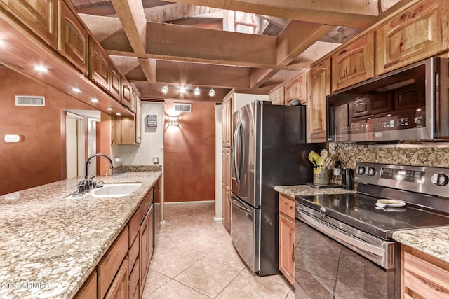 kitchen with sink, light stone counters, beamed ceiling, light tile patterned flooring, and appliances with stainless steel finishes