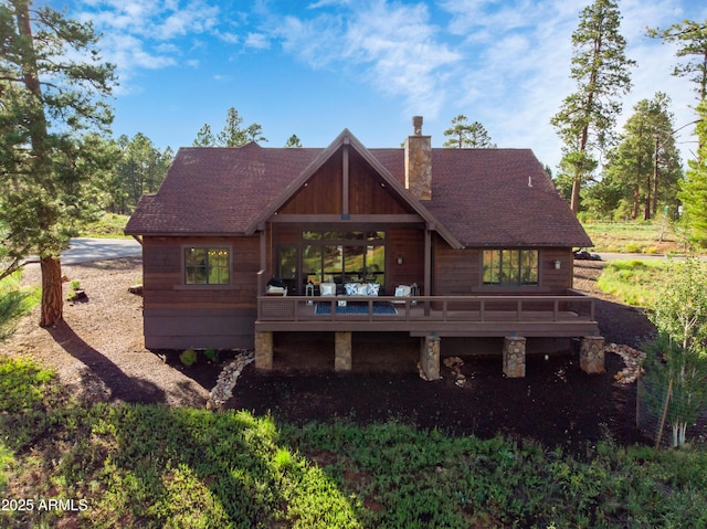 rear view of property featuring a wooden deck