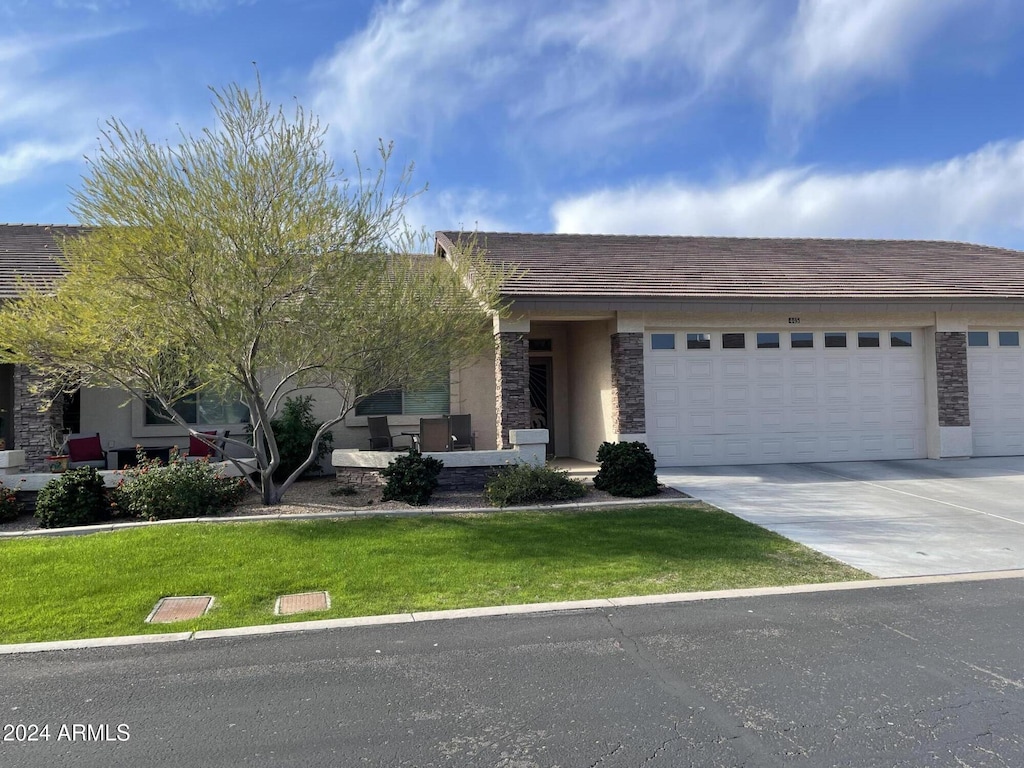 view of front of property with a garage and a front lawn