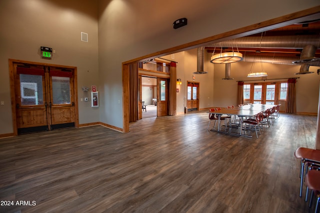 unfurnished living room with beamed ceiling, high vaulted ceiling, and dark hardwood / wood-style flooring