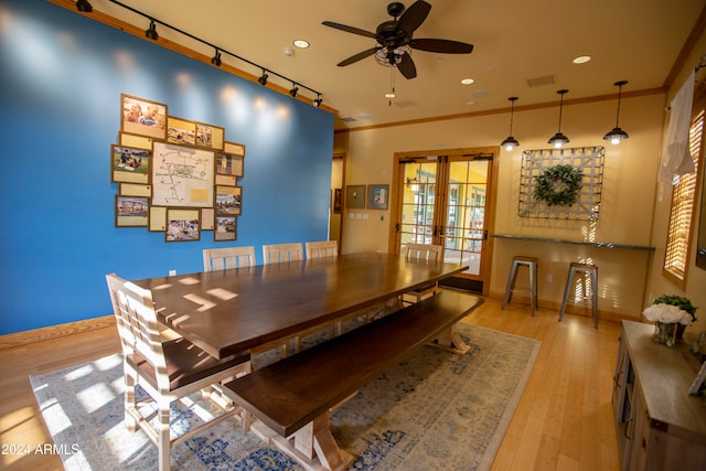 dining space featuring light wood-type flooring, french doors, track lighting, ceiling fan, and crown molding