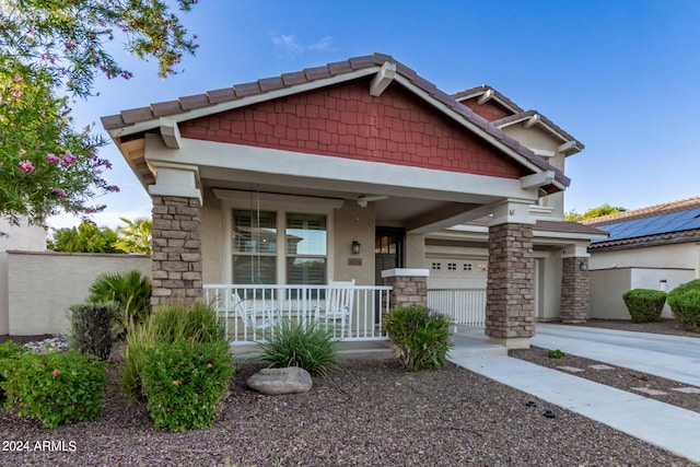 craftsman house with a garage, covered porch, and ceiling fan