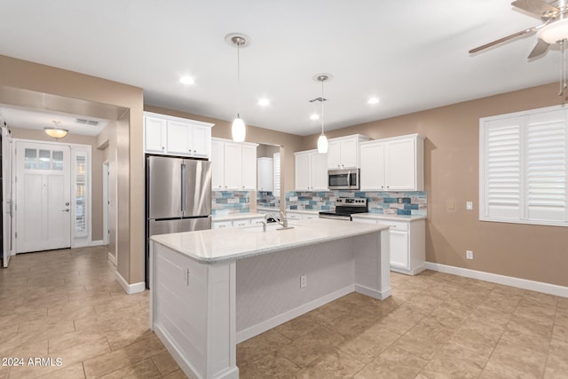 kitchen featuring ceiling fan, backsplash, white cabinets, appliances with stainless steel finishes, and light tile patterned floors