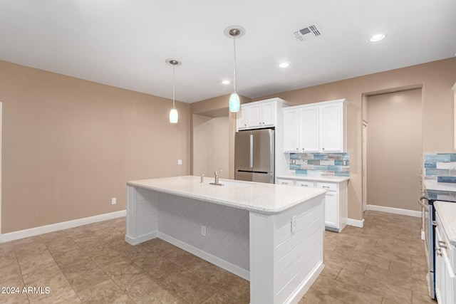 kitchen featuring backsplash, stainless steel refrigerator, white cabinetry, a center island with sink, and light tile patterned flooring