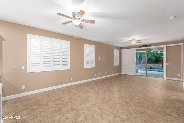 empty room with ceiling fan and light tile patterned floors