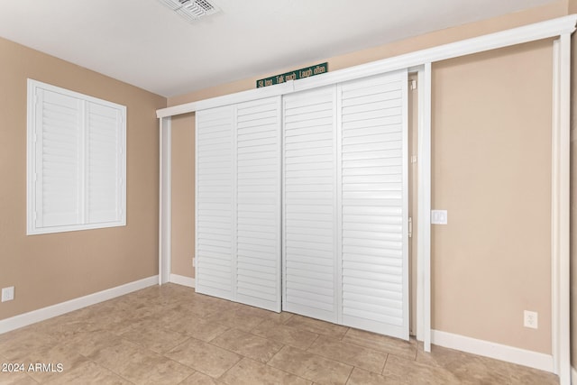 unfurnished bedroom with a closet and light tile patterned flooring