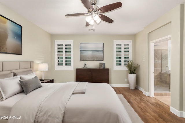 bedroom with ceiling fan, ensuite bathroom, and wood-type flooring