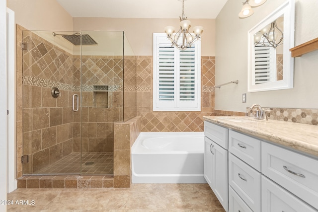 bathroom featuring tile patterned floors, independent shower and bath, vanity, and an inviting chandelier