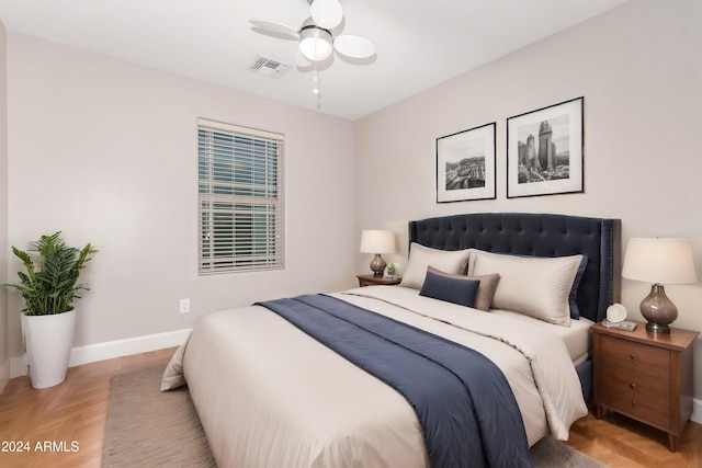 bedroom with ceiling fan and light parquet floors