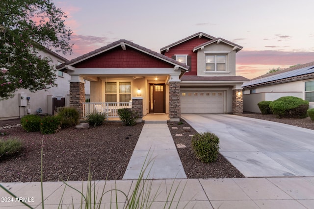 craftsman-style home with a garage, solar panels, and covered porch