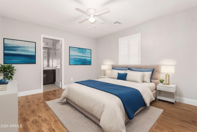 bedroom featuring hardwood / wood-style flooring, connected bathroom, and ceiling fan