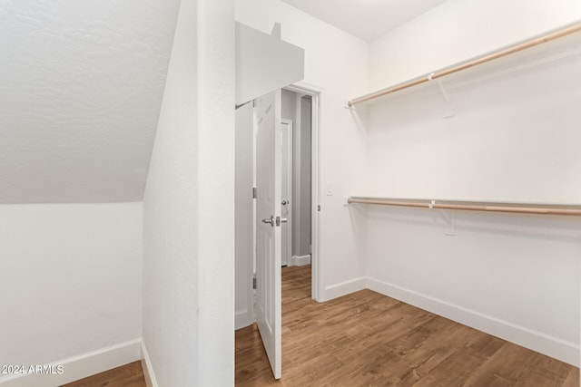 spacious closet with vaulted ceiling and hardwood / wood-style flooring