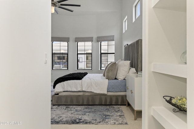 bedroom featuring multiple windows and a towering ceiling