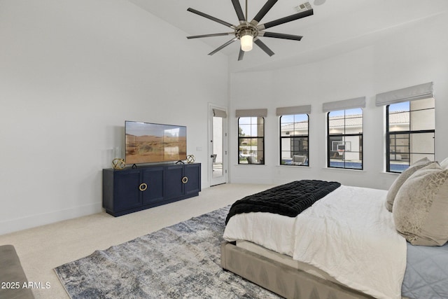 carpeted bedroom featuring a high ceiling and ceiling fan