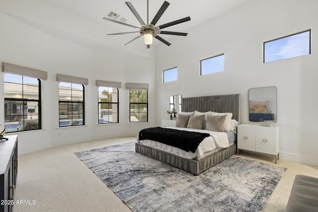 bedroom with carpet, a towering ceiling, and ceiling fan