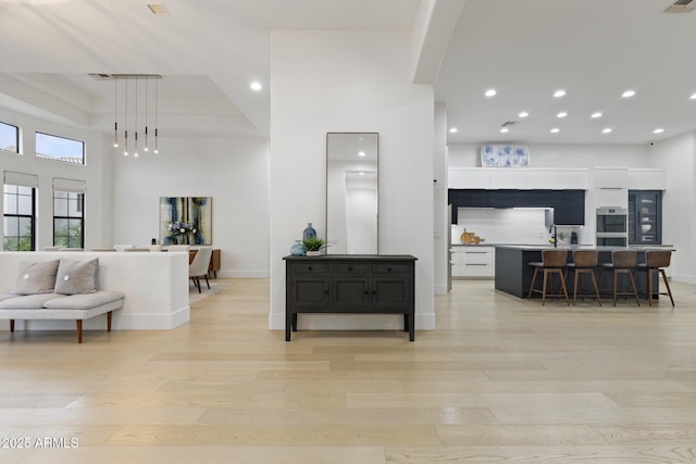 living room with a high ceiling and light hardwood / wood-style flooring