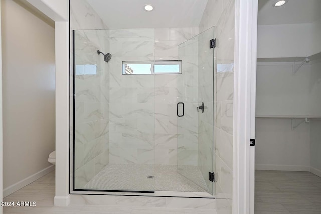 bathroom featuring toilet and a shower with shower door