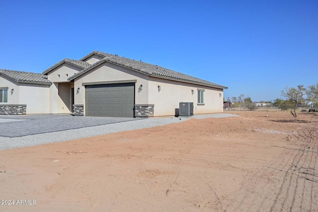 view of front of property with central air condition unit and a garage