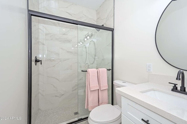 bathroom featuring vanity, toilet, and a shower with door