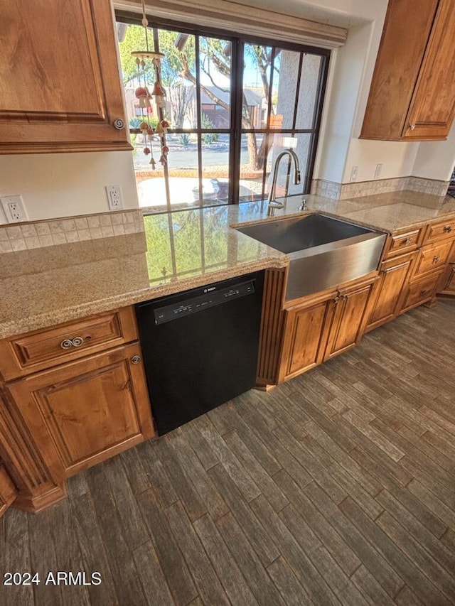 kitchen with sink, black dishwasher, a healthy amount of sunlight, and light stone counters