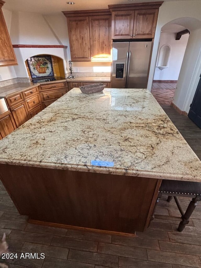 kitchen with light stone counters and stainless steel fridge