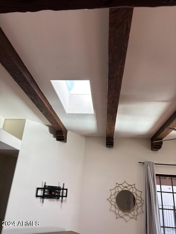 interior details featuring beam ceiling and a skylight