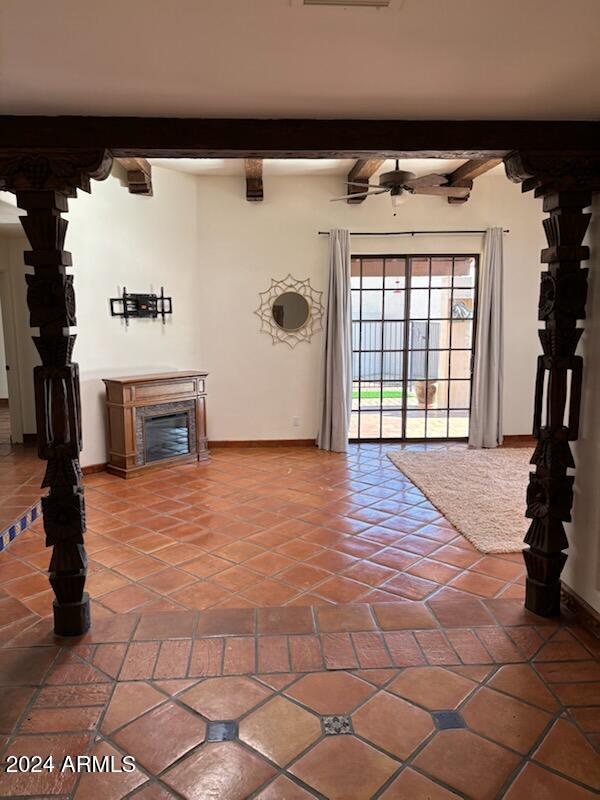 tiled foyer entrance with ceiling fan and beamed ceiling