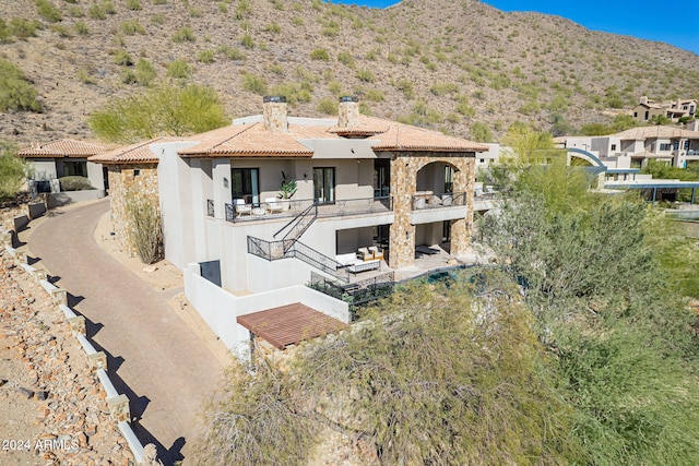 rear view of house featuring a mountain view and a balcony