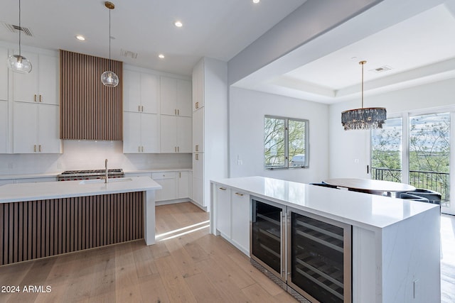 11328 E Dreyfus Ave, Scottsdale, AZ 85259 - kitchen featuring a kitchen island with sink, wine cooler, light wood-style flooring, recessed lighting, and light countertops