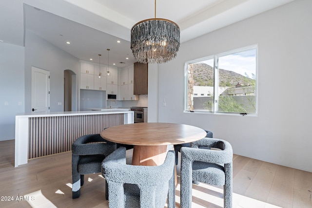 dining room with light hardwood / wood-style floors and a notable chandelier