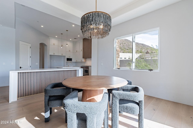 11328 E Dreyfus Ave, Scottsdale, AZ 85259 - dining room featuring light wood finished floors, a chandelier, arched walkways, and recessed lighting