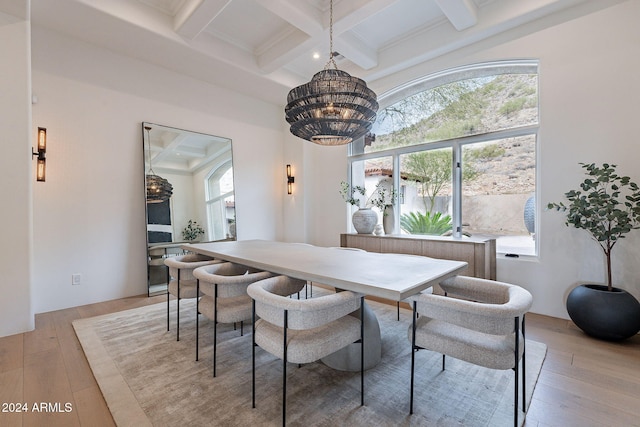 dining area with beam ceiling, light wood-type flooring, a wealth of natural light, and an inviting chandelier