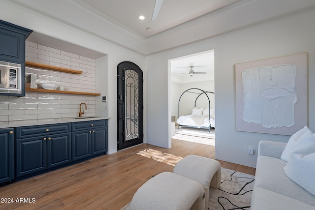 interior space with ceiling fan, sink, and light hardwood / wood-style floors