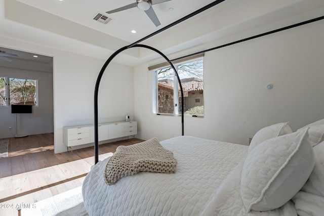 bedroom featuring hardwood / wood-style floors, radiator heating unit, and ceiling fan