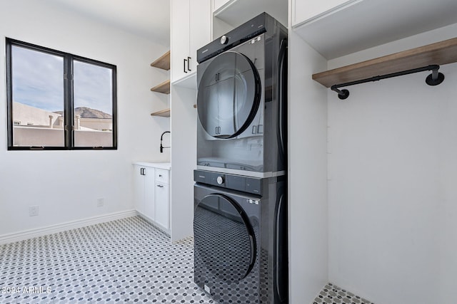11328 E Dreyfus Ave, Scottsdale, AZ 85259 - washroom featuring stacked washer / dryer, cabinet space, and light flooring