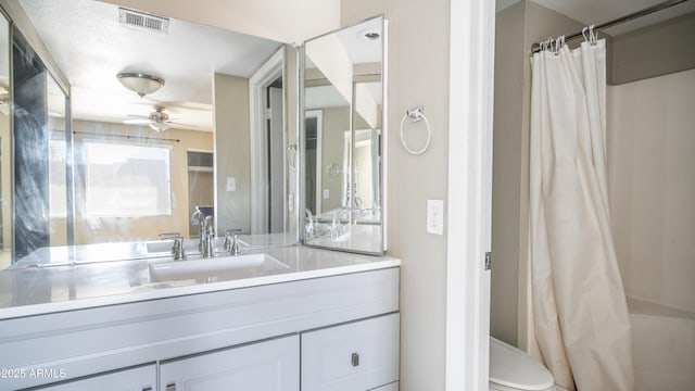 full bathroom featuring visible vents, a ceiling fan, toilet, curtained shower, and vanity