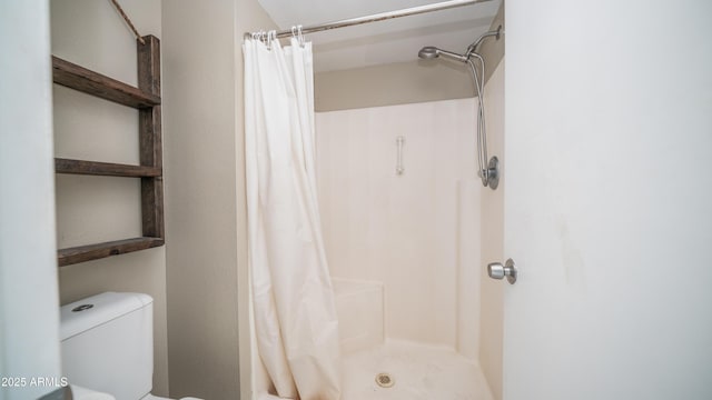 full bathroom featuring toilet and a shower stall