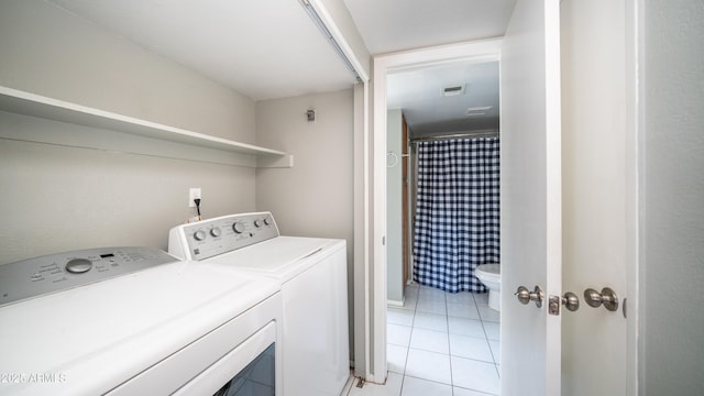 laundry room with washing machine and dryer, laundry area, visible vents, and light tile patterned floors