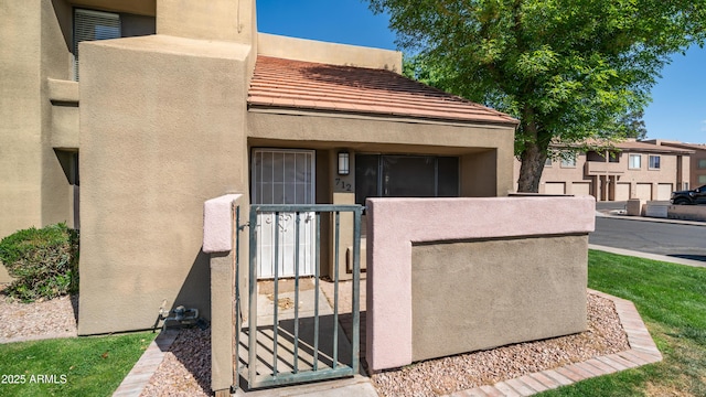 exterior space with a fenced front yard, a gate, and stucco siding