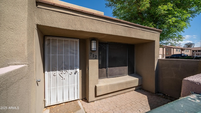 view of exterior entry featuring stucco siding